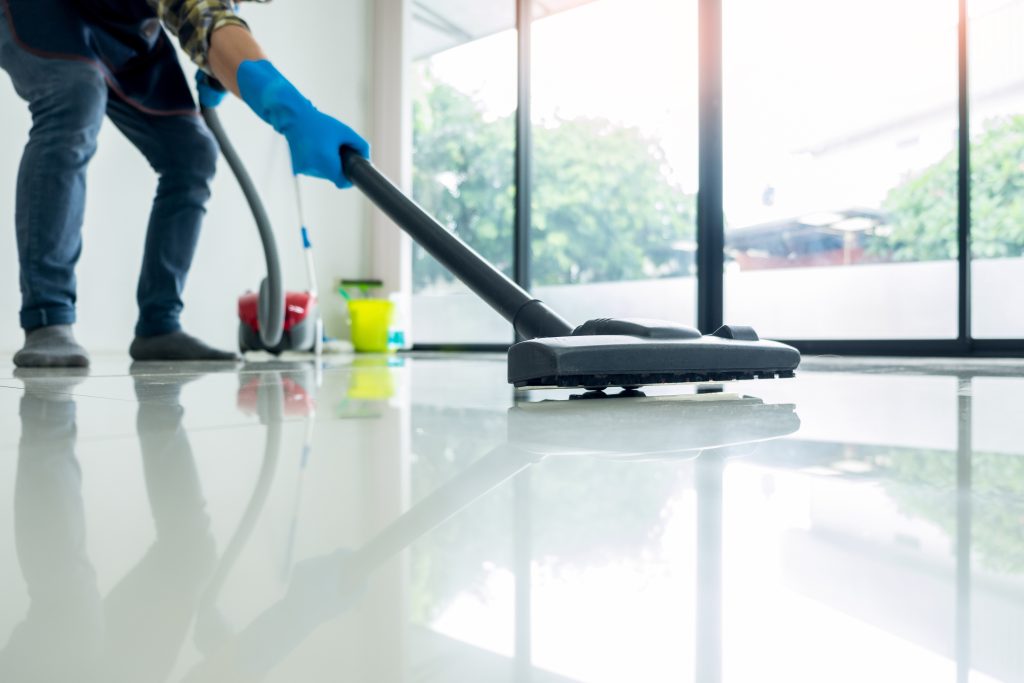 Young attractive man is cleaning vacuum commercial cleaning equi